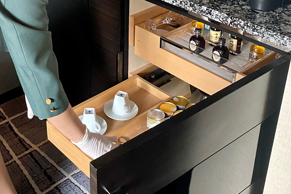 客室ないのティーセットをセッティングするスタッフ