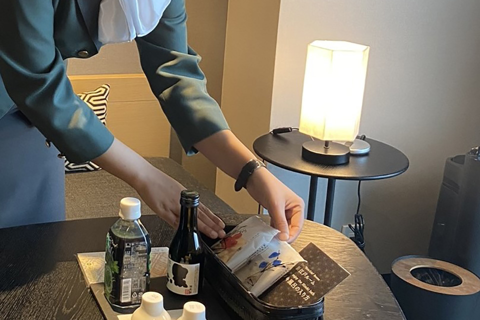 客室内のアメニティをセッティングするスタッフ