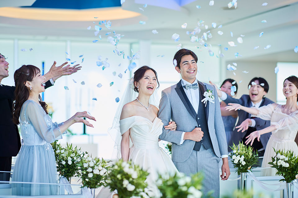 結婚式場で祝福される新郎新婦の写真